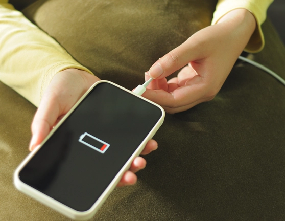 Teléfono mostrando batería a punto de agotarse mientras se carga