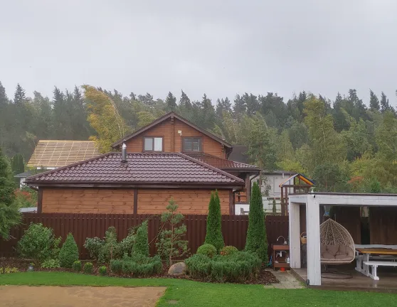 Casa rodeada de árboles con temporal de viento fuerte