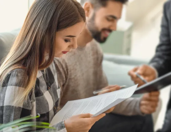 Dos personas leyendo atentamente documentos antes de firmar